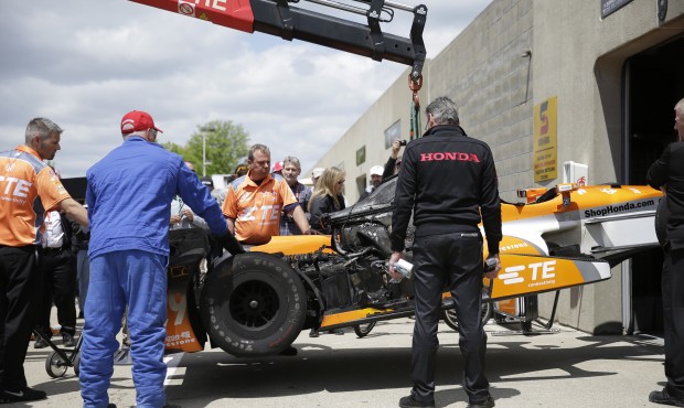 The car of Simona de Silvestro, of Switzerland, is lifted back to her garage after catching fire du...