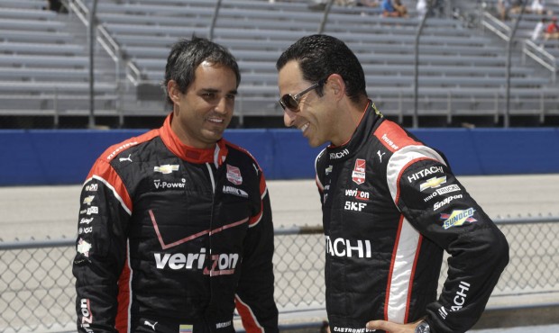 Juan Pablo Montoya, left, and Helio Castroneves wait during qualifying at the IndyCar Series race a...