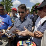 
              NASCAR driver Jeff Gordon signs autographs for fans as he makes hi way to the stage following a parade in his honor in Pittsboro, Ind., Thursday, July 23, 2015. Gordon will drive in Sunday's Brickyard 400.  (AP Photo/Michael Conroy)
            