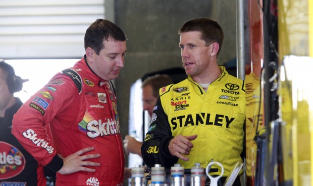 Kyle Busch, left, talks with Carl Edwards during practice for the NASCAR Sprint Cup Brickyard 400 a...