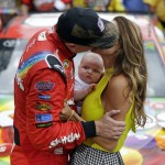 
              Kyle Busch (18) kisses his wife Samantha as their son Brexton looks on as he celebrates after winning the NASCAR Brickyard 400 auto race at Indianapolis Motor Speedway in Indianapolis, Sunday, July 26, 2
            