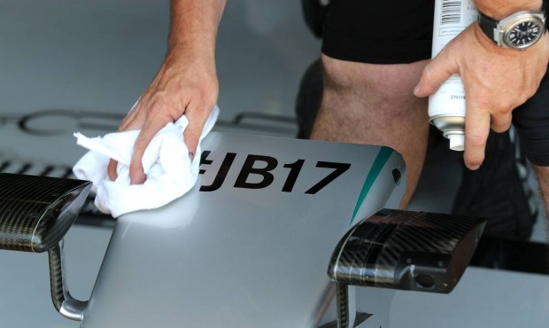 Mercedes technician cleans part of Germany’s Nico Rosberg’s car where a sign commemorat...
