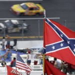 
              FILE - In this Oct. 7, 2007, file photo, a Confederate flags fly in the infield as cars come out of turn one during a NASCAR auto race at Talladega Superspeedway in Talladega, Ala. NASCAR is backing South Carolina Gov. Nikki Haley's call to remove the Confederate flag from the South Carolina Statehouse grounds in the wake of a massacre at a Charleston church, it said in a statement Tuesday, June 23, 2015. Though NASCAR bars the use of the flag in any official capacity, many fans fly the flag at their races.  (AP Photo/Rob Carr, File)
            