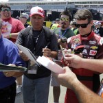 
              Jeff Gordon signs autographs before practice for Sunday's NASCAR Coca-Cola 600 Sprint Cup series auto race at Charlotte Motor Speedway in Concord, N.C., Thursday, May 21, 2015. (AP Photo/Chuck Burton)
            