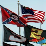 
              FILE - In this Feb. 15, 2008, file photo, flags, including a Confederate flag, fap in the wind during practice for the NASCAR Sprint Cup Series Daytona 500 auto race at Daytona International Speedway in Daytona Beach, Fla.  NASCAR is backing South Carolina Gov. Nikki Haley's call to remove the Confederate flag from the South Carolina Statehouse grounds in the wake of a massacre at a Charleston church, it said in a statement Tuesday, June 23, 2015. Though NASCAR bars the use of the flag in any official capacity, many fans fly the flag at their races. (AP Photo/Darryl Graham, File)
            