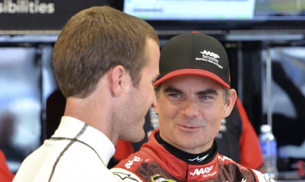 Jeff Gordon, right, talks with Kasey Kahne as they wait for the track to dry so practice may resume...