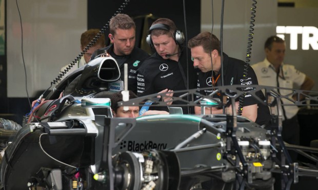 Team members gather around the car of Britain’s Lewis Hamilton before the British Formula One...