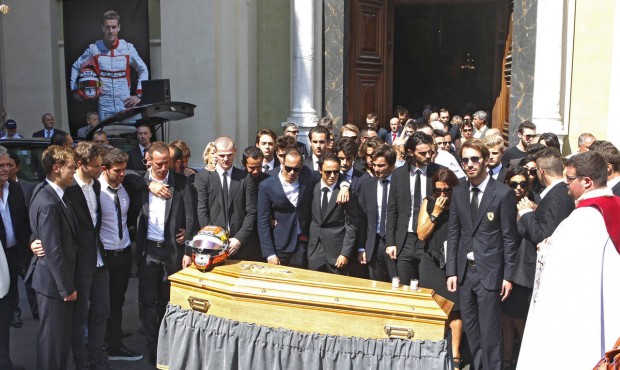 Formula one drivers and family members stand in front of the casket of French Formula One driver Ju...