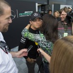 
              Mercedes driver Nico Rosberg from Germany, centre left, receives a kiss before being interviewed in the paddock area before the British Formula One Grand Prix meeting at Silverstone circuit, Silverstone, England, Thursday, July 2, 2015. The British Formula One Grand Prix will be held on Sunday July 5. (AP Photo/Jon Super)
            