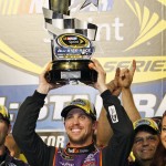 
              Denny Hamlin holds the trophy in Victory Lane after winning the NASCAR Sprint All-Star auto race at Charlotte Motor Speedway in Concord, N.C., Saturday, May 16, 2015. (AP Photo/Terry Renna)
            