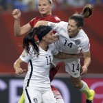 
              United States' Morgan Brian (14) lands on teammate Ali Kreiger (11) after crashing into Germany's Alexandra Popp, back, during the first half of a semifinal in the Women's World Cup soccer tournament, Tuesday, June 30, 2015, in Montreal, Canada. (Ryan Remiorz/The Canadian Press via AP)
            