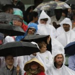 
              Spectators shelter from the rain on No.1 Court, at the All England Lawn Tennis Championships in Wimbledon, London, Wednesday July 8, 2015. (AP Photo/Pavel Golovkin)
            