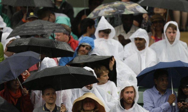 Spectators shelter from the rain on No.1 Court, at the All England Lawn Tennis Championships in Wim...