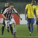 
              Paraguay's Victor Caceres celebrates after the penalty shootout during a Copa America quarterfinal soccer match at the Ester Roa Rebolledo Stadium in Concepcion, Chile, Saturday, June 27, 2015. Paraguay defeated Brazil 4-3 in a penalty shootout after a 1-1 draw on Saturday to advance to the semifinals of the Copa America. At right Brazil's Miranda and Fernandinho.(AP Photo/Natacha Pisarenko)
            