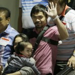
              Filipino boxer and Congressman Manny Pacquiao waves to the crowd upon arrival with his family including his wife Jinkee and youngest son Israel (bottom left) Wednesday, May 13, 2015 at the Ninoy Aquino International Airport at suburban Pasay city south of Manila, Philippines. Pacquiao, who was defeated by Floyd Mayweather Jr. in their welterweight fight in Las Vegas May 2, faces lawsuits allegedly for not disclosing his shoulder injury before the fight. (AP Photo/Bullit Marquez)
            