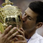 
              Novak Djokovic of Serbia kisses the trophy after winning the men's singles final against Roger Federer of Switzerland at the All England Lawn Tennis Championships in Wimbledon, London, Sunday July 12, 2015. Djokovic won the match 7-6, 6-7, 6-4, 6-3. (AP Photo/Alastair Grant)
            