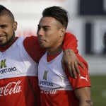 
              Chile's Arturo Vidal, left, and teammate Eduardo Vargas, stand arm in arm during a practice session in Santiago, Chile, Saturday, June 27, 2015. Chile will play Peru in a Copa America semifinal game, Monday. (AP Photo/Jorge Saenz)
            
