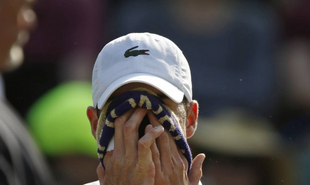John Isner of the United States wipes his face during a change of ends break as he plays Marin Cili...