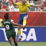 
              Sweden's Nilla Fischer (5) heads the ball past Nigeria's Desire Oparanozie (9) during the first half of a FIFA Women's World Cup soccer match in Winnipeg, Manitoba, Monday, June 8, 2015. (John Woods/The Canadian Press via AP) MANDATORY CREDIT
            
