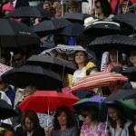 
              Spectators shelter under umbrellas as rain interrupts play on Court No. 1, during the men's quarterfinal singles match between Roger Federer of Switzerland and Gilles Simon of France,  at the All England Lawn Tennis Championships in Wimbledon, London, Wednesday July 8, 2015. (AP Photo/Pavel Golovkin)
            