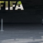 
              A man walks next to the FIFA logo at the FIFA headquarters in Zurich, Switzerland, Wednesday morning, May 27, 2015. Swiss federal prosecutors say they have opened criminal proceedings related to the awarding of the 2018 and 2022 World Cups. The prosecutors' office says the proceedings are against "persons unknown on suspicion of criminal mismanagement and of money laundering" in connection with the votes won by Russia and Qatar. (Ennio Leanza/Keystone via AP)
            