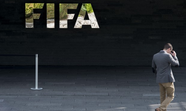 n A man walks next to the FIFA logo at the FIFA headquarters in Zurich, Switzerland, Wednesday morn...