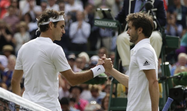 Roger Federer of Switzerland, left, shakes hands at the net with Gilles Simon of France after winni...