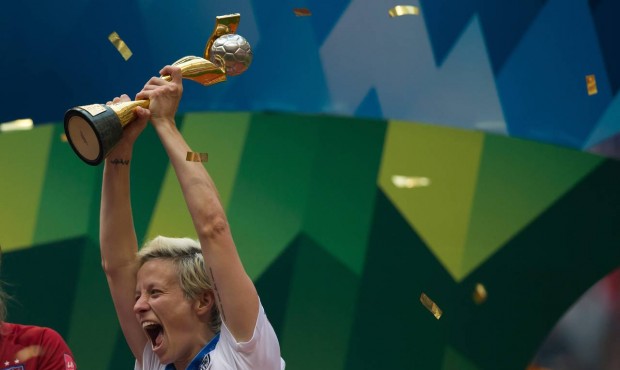 United States’ Megan Rapinoe hoists the trophy as she celebrates after defeating Japan to win...