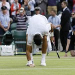 
              Novak Djokovic of Serbia touches the ground after winning against the Marin Cilic of Croatia after winning the men's quarterfinal singles match at the All England Lawn Tennis Championships in Wimbledon, London, Wednesday July 8, 2015. Djokovic won 6-4, 6-4, 6-4. (AP Photo/Kirsty Wigglesworth)
            