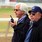 
              Hall of Fame trainer Bob Baffert, left, talks to his assistant via two-way radio as they wait for the track to be harrowed before bringing out Belmont Stakes entrant American Pharoah at Belmont Park in Elmont, N.Y., Friday, June 5, 2015. At right is Bernie Sciappa.  American Pharoah will try to become horse racing's 12th Triple Crown winner and first since Affirmed in 1978 when he runs in the Belmont Stakes on Saturday.  (AP Photo/Garry Jones)
            