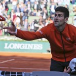 
              Serbia's Novak Djokovic throws his armband  after defeating France's Richard Gasquet during their fourth round match of the French Open tennis tournament at the Roland Garros stadium, Monday, June 1, 2015 in Paris.  (AP Photo/David Vincent)
            