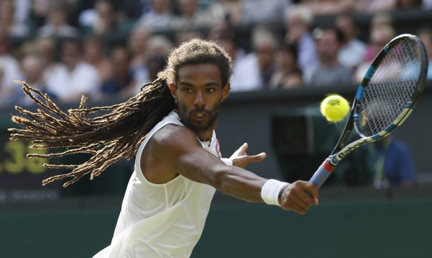 Dustin Brown of Germany returns a ball to Rafael Nadal of Spain during their singles match at the A...