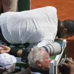 
              France's Jo-Wilfried Tsonga leans on a fridge to stretch his shoulder muscle in the semifinal match of the French Open tennis tournament against Switzerland's Stan Wawrinka at the Roland Garros stadium, in Paris, France, Friday, June 5, 2015. (AP Photo/David Vincent)
            