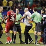 
              Panama's Anibal Godoy (20) approaches referee Mark Geiger, left, as officials rush in to protect him at the conclusion of a CONCACAF Gold Cup soccer semifinal between Panama and Mexico on Wednesday, July 22, 2015, in Atlanta. Mexico won 2-1. (AP Photo/David Goldman)
            