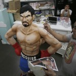 
              Zach Yonzon, owner of The Bunny Baker cafe, puts finishing touches on the life-sized cake of Filipino boxer Manny Pacquiao Saturday, May 2, 2015 at his bakeshop at suburban Quezon city, northeast of Manila, Philippines. Yonzon who says he was bored with making traditional cakes sculpted the one-of-a-kind life-sized cake in the image of Pacquiao to mark the Filipino champion’s megabout with American Floyd Mayweather. Yonzon, says his wife Aila and six of his staff helped finish the 167-centimeter (66-inch) chocolate cake of Pacquiao with arms akimbo on Saturday after working 24 hours at the cafe. (AP Photo/Bullit Marquez)
            