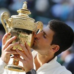 
              FILE - In this July 6, 2014, file photo, Novak Djokovic of Serbia kisses the trophy after defeating Roger Federer of Switzerland in the men's singles final at the All England Lawn Tennis Championships at Wimbledon in London. (AP Photo/Ben Curtis, File)
            