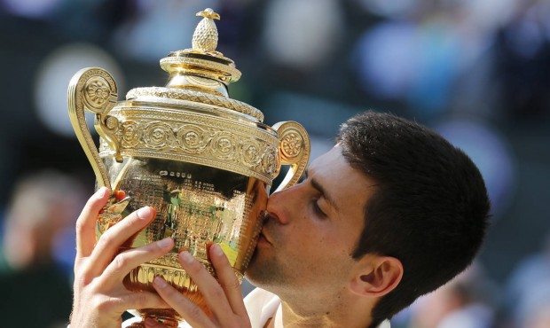 FILE – In this July 6, 2014, file photo, Novak Djokovic of Serbia kisses the trophy after def...
