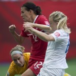 
              Canada's Christine Sinclair sends a shot past England goalkeeper Karen Bardsley as Laura Bassett, right, watches during the first half of a quarterfinal of the Women's World Cup soccer tournament, Saturday, June 27, 2015, in Vancouver, British Columbia, Canada. (Jonathan Hayward/The Canadian Press via AP
            
