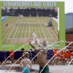 
              Six-year-old Harvey enjoys playing with water as the Wimbledon Tennis Championships are seen on a huge screen in London, Wednesday, July 1, 2015.  Britain is preparing itself for the hottest day of the year Wednesday, with temperatures possibly rising to 34C (93F).(AP Photo/Frank Augstein)
            