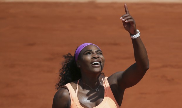 Serena Williams of the U.S. gestures she has trouble returning a high ball against the sunlight in ...