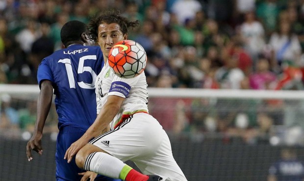 Mexico midfielder Andres Guardado kicks the ball in front of Guatemala defender Deniss Lopez (15) d...