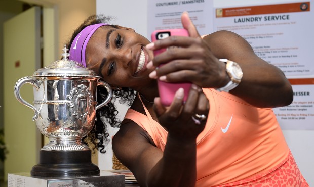 Serena Williams of the U.S. poses for a selfie with the trophy in the cloakroom after winning the F...