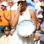 
              Garbine Muguruza of Spain cries as she holds the runners up trophy during the trophy ceremony after losing to Serena Williams of the United States, at the All England Lawn Tennis Championships in Wimbledon, London, Saturday July 11, 2015. (Sean Dempsey/Pool Photo via AP)
            