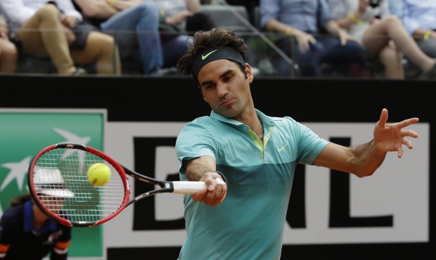 Roger Federer, of Switzerland, returns the ball to Tomas Berdych, of Czech Republic, during a quart...