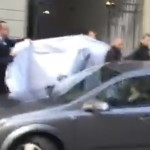 
              Picture taken from a cell phone video shows hotel employees holding a blanked to hide the identity of a person led out of a side entrance of the Baur au Lac hotel to a waiting car in Zurich, Switzerland, Wednesday, May 27, 2015. Six soccer officials were arrested and detained by Swiss police on Wednesday pending extradition at the request of U.S. authorities after a raid in the luxury hotel. The case involves bribes "totaling more than US$ 100 million" linked to commercial deals dating back to the 1990s for soccer tournaments in the United States and Latin America, the Swiss Federal Office of Justice said in a statement. (AP Photo/Rob Harris)
            