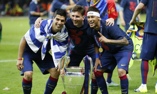 Barcelona’s Lionel Messi, centre, Neymar and Luis Suarez, left, celebrate with the trophy aft...