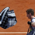
              Britain's Andy Murray throws his towel as he leaves center court while Serbia's Novak Djokovic celebrates winning the semifinal match of the French Open tennis tournament in five sets 6-3, 6-3, 5-7, 5-7, 6-1, at the Roland Garros stadium, in Paris, France, Saturday, June 6, 2015. (AP Photo/Michel Euler)
            