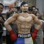 
              Zach Yonzon, second from right, owner of The Bunny Baker cafe, along with his staff poses with the life-sized cake of Filipino boxer Manny Pacquiao Saturday, May 2, 2015 at his bakeshop at suburban Quezon city, northeast of Manila, Philippines. Yonzon who says he was bored with making traditional cakes sculpted the one-of-a-kind life-sized cake in the image of Pacquiao to mark the Filipino champion’s megabout with American Floyd Mayweather. Yonzon, says his wife Aila and six of his staff helped finish the 167-centimeter (66-inch) chocolate cake of Pacquiao with arms akimbo on Saturday after working 24 hours at the cafe. (AP Photo/Bullit Marquez)
            