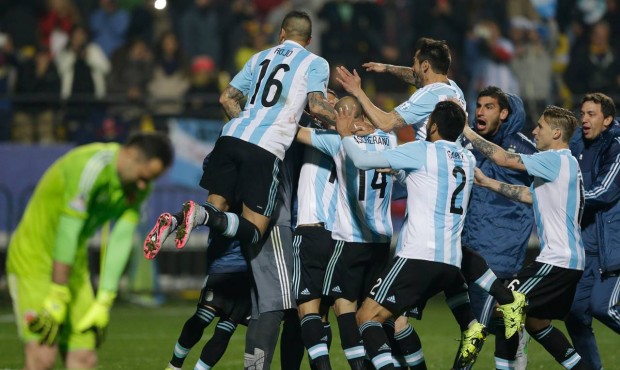 Argentina’s players jump over Carlos Tevez after scored the winning penalty kick against Colo...