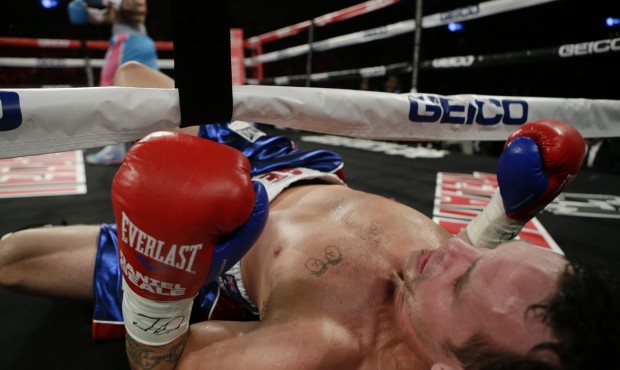 Daniel Geale, of Australia, falls out of the ring after being knocked down by Miguel Cotto, of Puer...